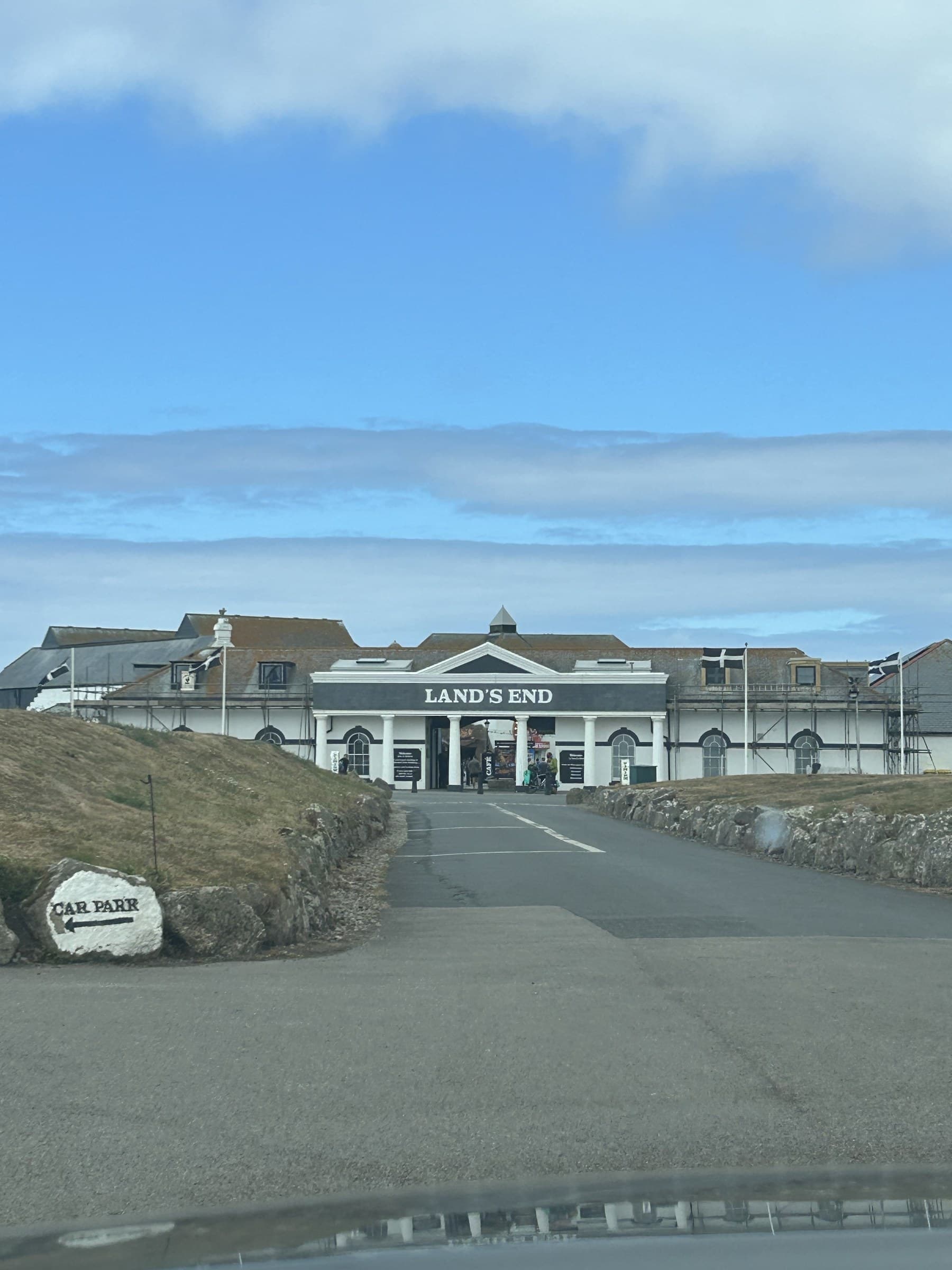 The Land's End visitor building, with a hand-painted 'Car Parr' sign in the foreground