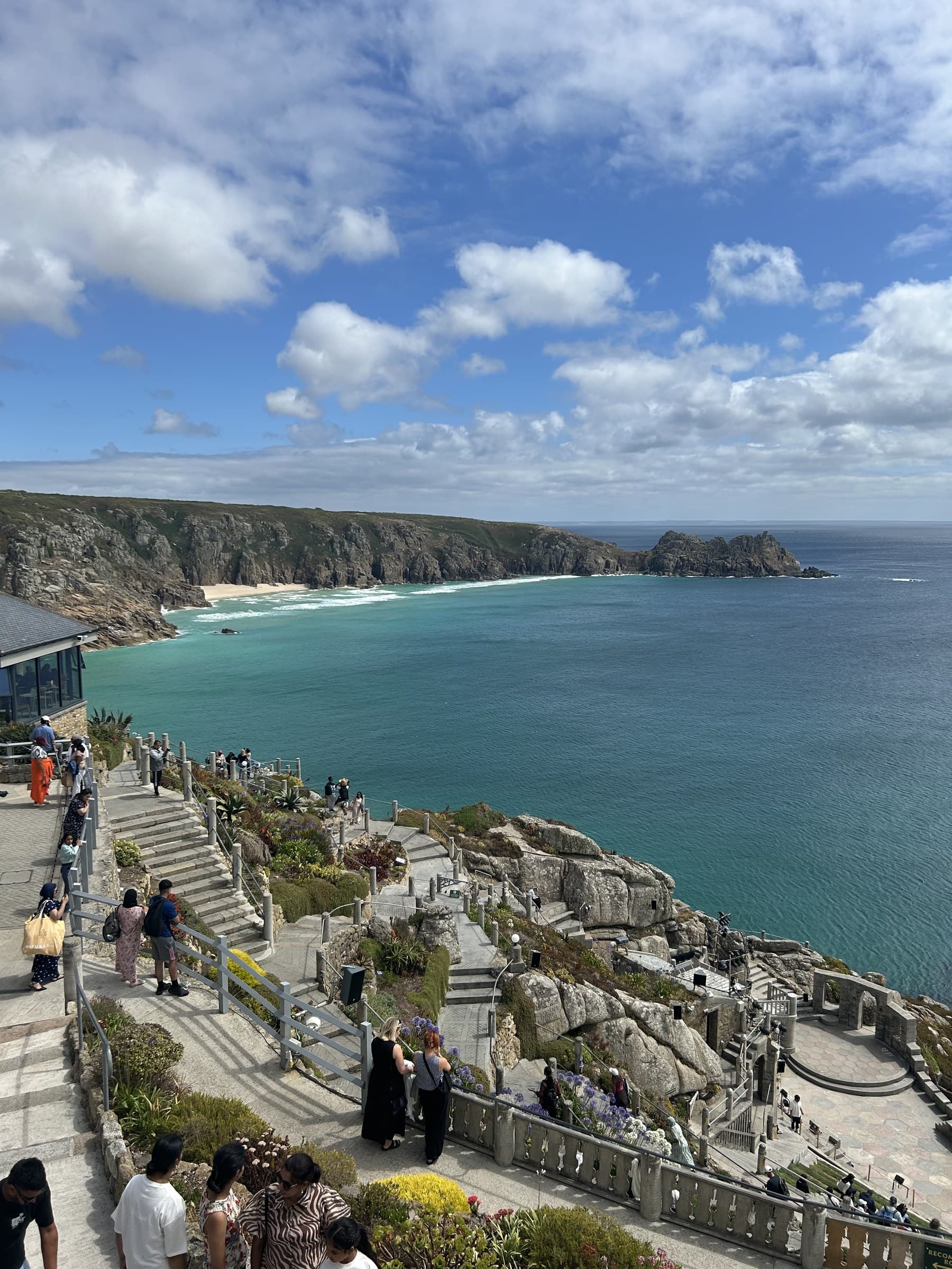 Minack Theatre's amphitheatre carved into the cliff, seating descending toward the sea